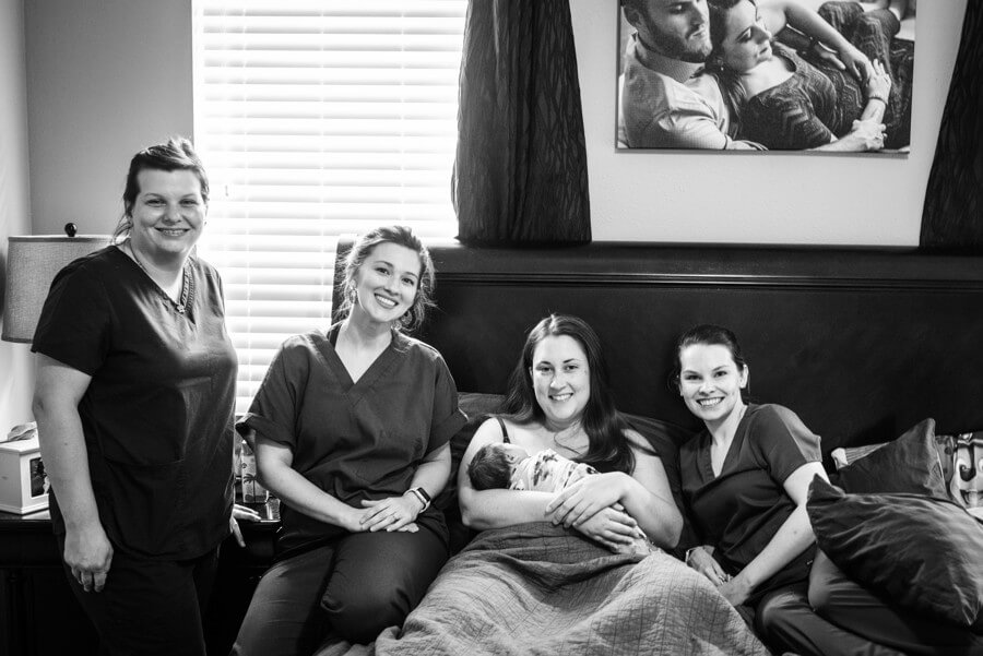 journey birth center conroe texas. Image of midwives surrounding new mother whose just given birth.